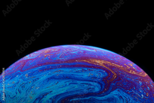 Burbuja de jabón simulando la atmosfera de un planeta con diferentes formas, colores y el fondo negro