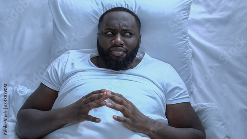 Photos Nervous man drumming fingers lying in bed, erectile dysfunction, mans health