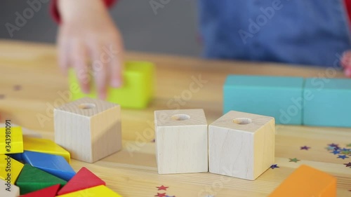 Online distance learning at home during quarantine. A smart child with glasses collects a multi-colored constructor at a table in a classroom.