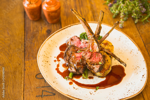 grilled Australian lamb rack with roasted sweet potatoes, charred broccolini and pomegranate demi-glace photo