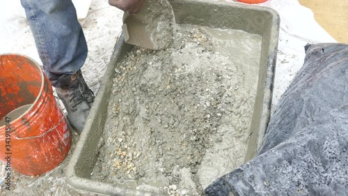 Construction worker mixes concrete in a plastic tub, with good sound 4K