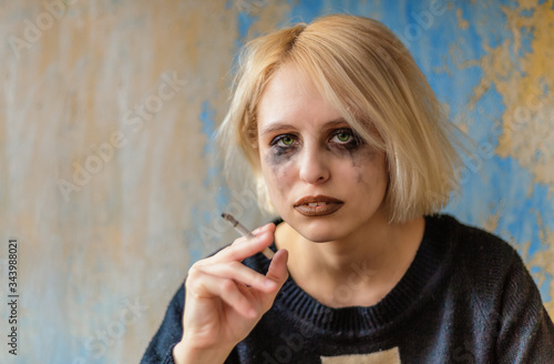 Portrait of sad woman with cigarette and makeup running down