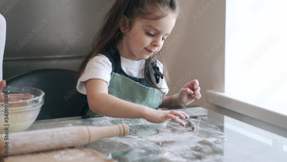 A pretty mother and daughter are making pastry for cookies. The kid and parent are celebrating Mother's day. A pretty mother and daughter are making pastry for cookies. The kid and parent are celebrating Mother's day.