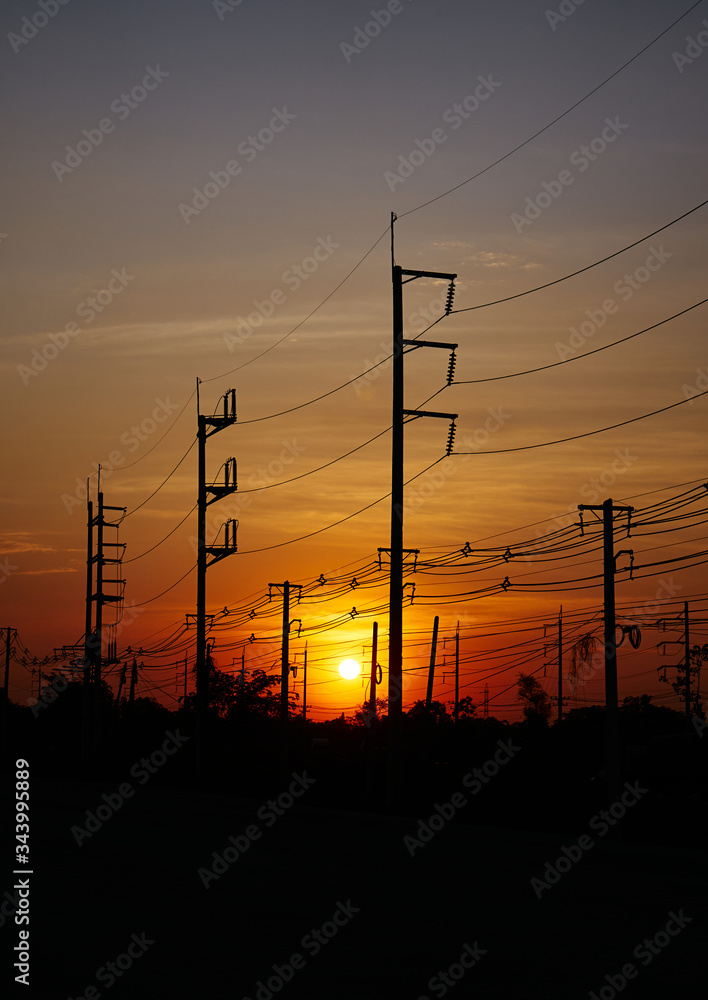 The electric poles and electric lines with a sky of sunset