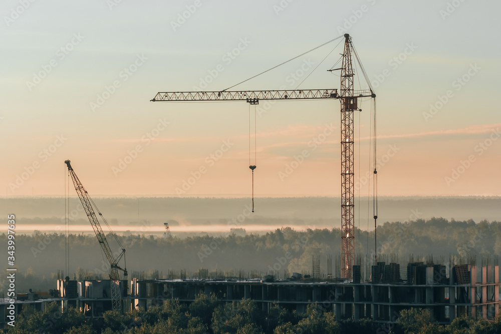 Building of High-rise Apartment in Forest. Industrial landscape with Construction Tower Cranes. City Business Project, Mortgage Company