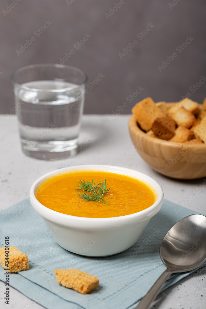 Pumpkin and carrot soup with fresh dill on table Pumpkin and carrot soup with fresh dill on table