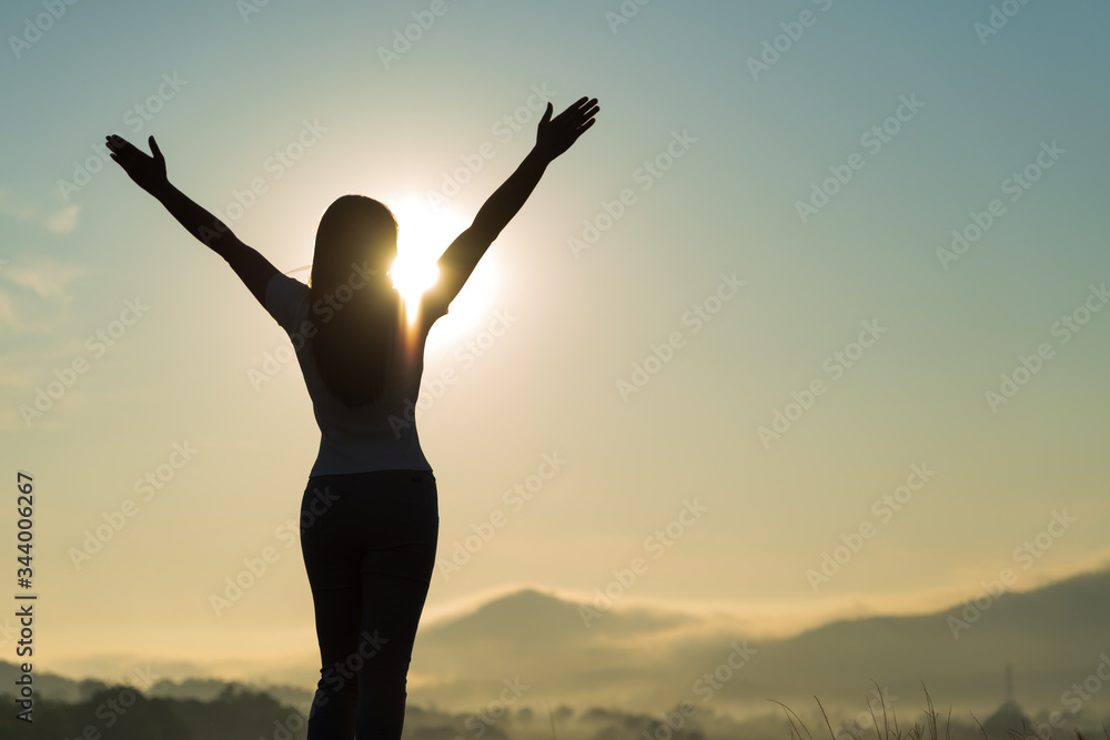 Silhouette of happy woman spreading arms and watching the mountain. Travel Lifestyle success concept adventure active vacations outdoor freedom emotions. Silhouette of happy woman spreading arms and watching the mountain. Travel Lifestyle success concept adventure active vacations outdoor freedom emotions.