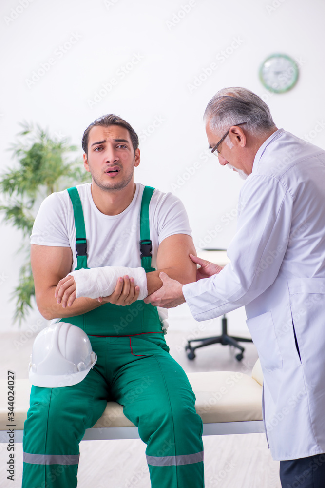 Obraz premium Young male contractor visiting old doctor