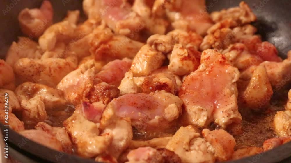 Timelapse of chicken breast pieces being fried in a pan, large bits seasoned with paprika and garlic powder being cooked. Ingredient in many asian dishes Timelapse of chicken breast pieces being fried in a pan, large bits seasoned with paprika and garlic powder being cooked. Ingredient in many asian dishes