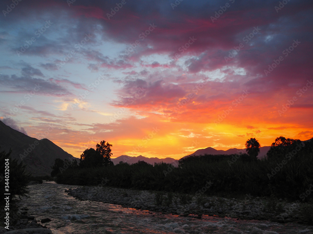 Intense sunset over a river in a mountainous valley
