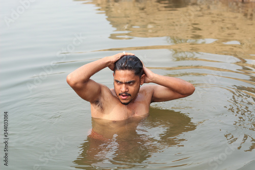 young man model bathing in a river