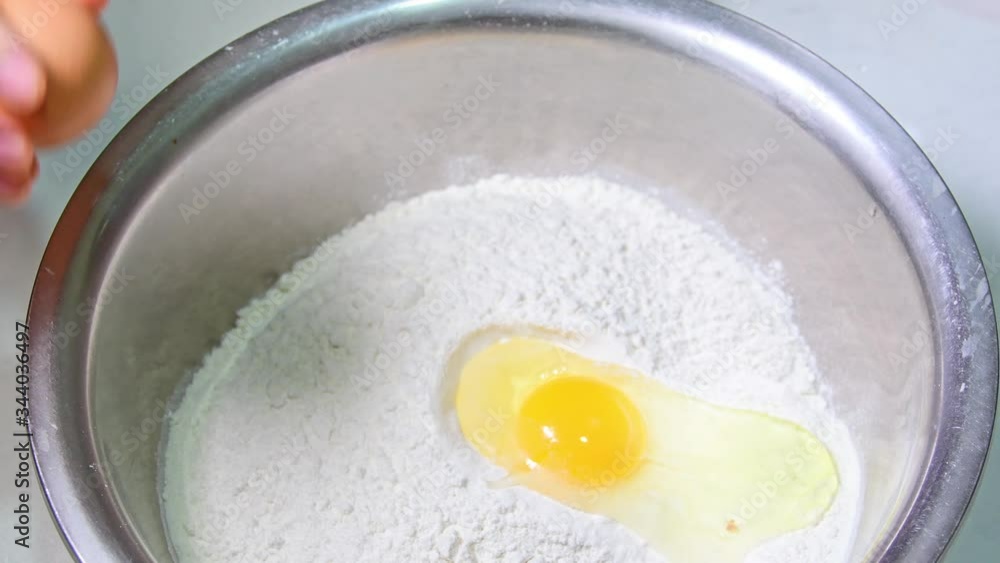 Stirring falling eggs with flour in a glass bowl. New coronavirus. Quarantined at home. Mix and dough. Prepare for homemade bread. Healthy lifestyle Stirring falling eggs with flour in a glass bowl. New coronavirus. Quarantined at home. Mix and dough. Prepare for homemade bread. Healthy lifestyle