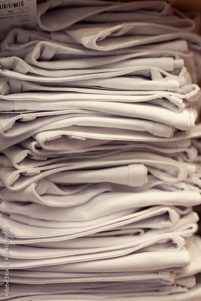 details of clothing and textile on display in clothing store folded, stacked and hanging details of clothing and textile on display in clothing store folded, stacked and hanging