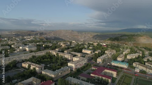 Wallpaper Mural 08. Aerial view of city with low buildings. The camera goes up and overlooks huge quarry and ore dumps. Outside the city Ural mountains. Summer, evening. Russia, Chelyabinsk region, Satka city
 Torontodigital.ca