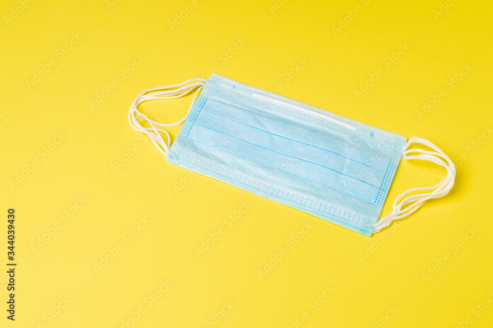 Medical or surgical face mask isolated on yellow background, coronavirus and infection protection. Medical or surgical face mask isolated on yellow background, coronavirus and infection protection.