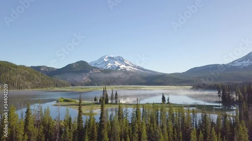 Aerial view of sunrise at Sparks Lake, Bend, Oregon, USA
Drone panorama view of picturesque northwest natural landscape with beautiful snow capped mountains in distance past tranquil lake. Volcano