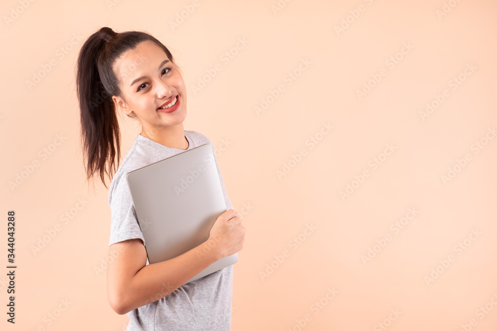 Portriat young asian girl woman happy and success holding computer laptop smile and confident isolated over pink background Portriat young asian girl woman happy and success holding computer laptop smile and confident isolated over pink background