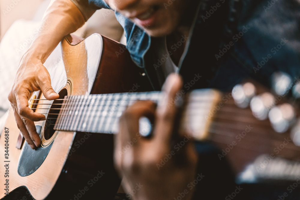 Fototapeta premium Close up of man's hands playing acoustic guitar