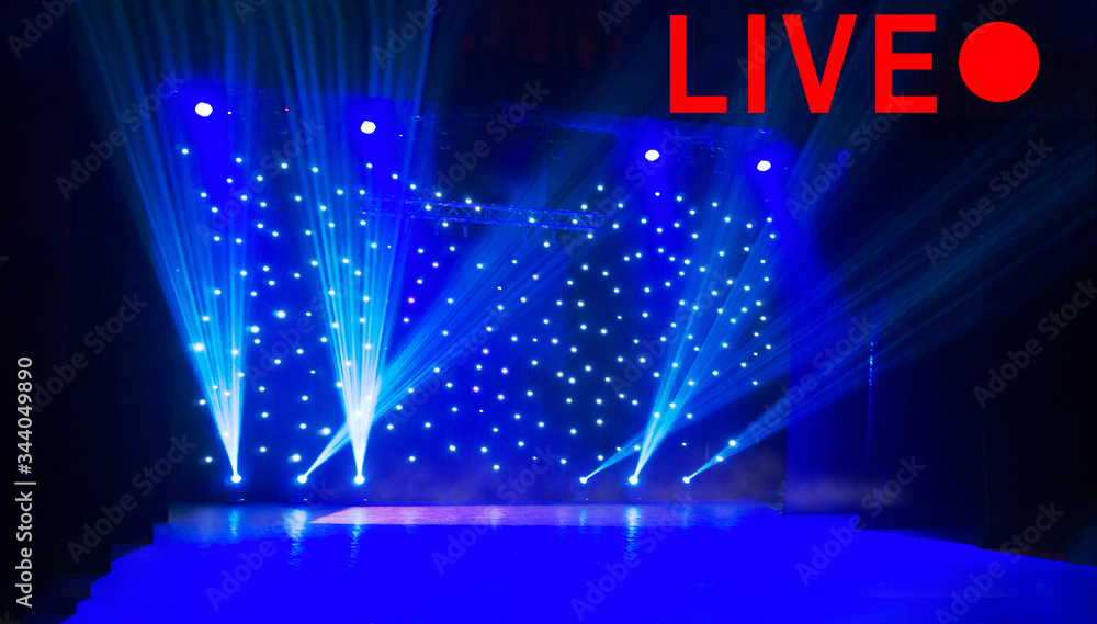Text LIVE and red circle on blurred show background. Empty stage and sparkling stage lights at time of entertainment show. Concept live performance concert on the Internet, online show
