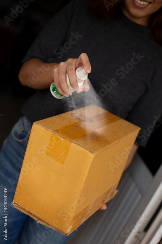 woman disinfecting package that arrived at her home
