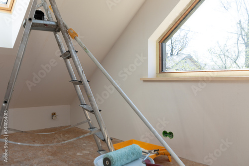 Home improvement. Painting tools roller, paint bucket and paintbrush in a natural light.