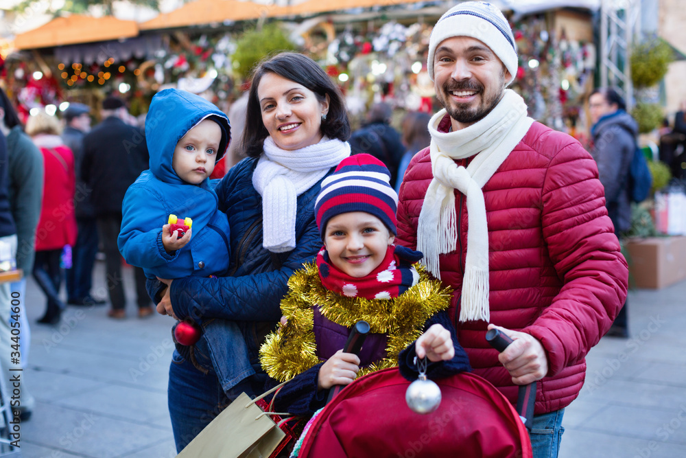 Parents with kids choosing X-mas decorations in market