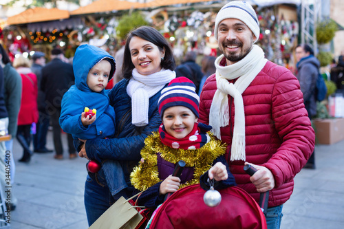 Parents with kids choosing X-mas decorations in market