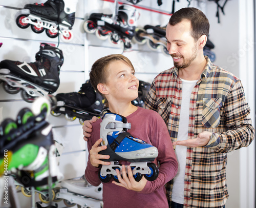 Smiling father and boy boasting roller-skates