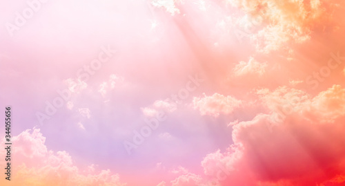 orange and pink sunshine light in bright sky and clouds