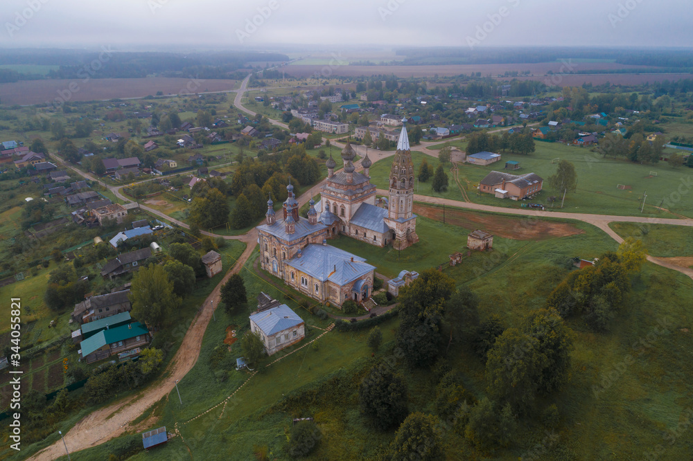 View of the old temple complex in the village of Parskoe on a foggy September morning (aerial photography). Ivanovo region, Russia