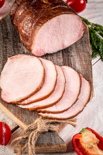 Sliced delicious ham served on a wooden table with vegetables, above view. Christmas dinner