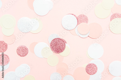 Multicolor pink, gold and white confetti on the light peach pink background, holiday celebration backdrop, Flat lay style with place for text