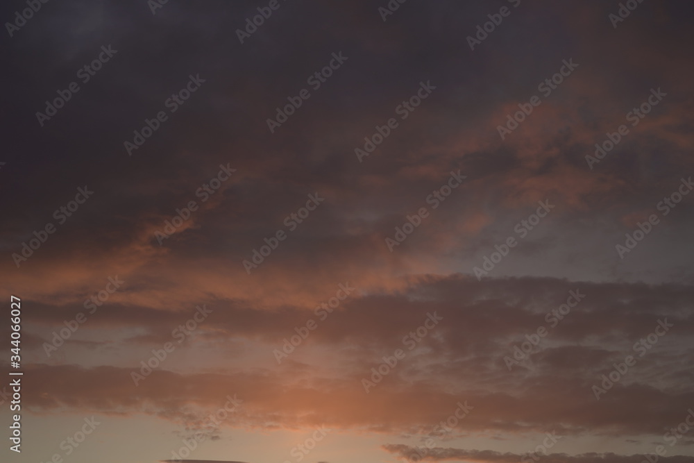Beautiful evening blue sky at sunset with flaming bright light clouds. A warm summer evening at sunset. Beautiful evening blue sky at sunset with flaming bright light clouds. A warm summer evening at sunset.