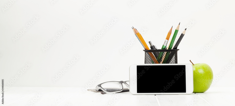 Workplace with smartphone, supplies and apple Workplace with smartphone, supplies and apple
