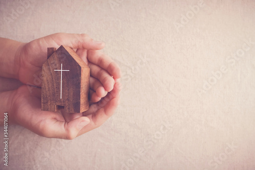 Child hands holding church, serving God, praying hands, online digital home church service, social distancing, isolation, lockdown concept photo