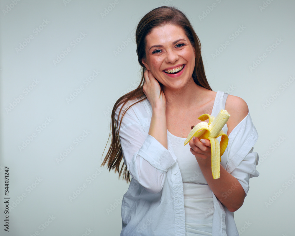 Woman dressed white shirt eating banana. Woman dressed white shirt eating banana.