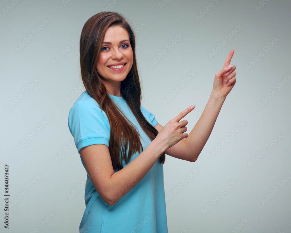 Smiling woman in blue dress pointing at side with fingers. Smiling woman in blue dress pointing at side with fingers.