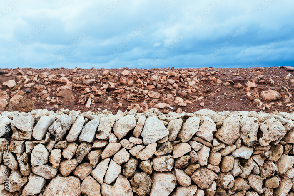 Abstract organic horizontal composition of red earth, white rocks and blue sky with clouds. Abstract organic horizontal composition of red earth, white rocks and blue sky with clouds.