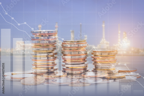 Gas and petroleum declining or price decreasing or drop concept; double exposure of coins stack and oil refinery, with growing trend chart graph.