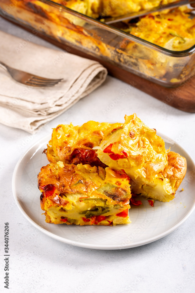 Vegetable clafoutis, savory pie with bell peppers, peas, onions and tomatoes.