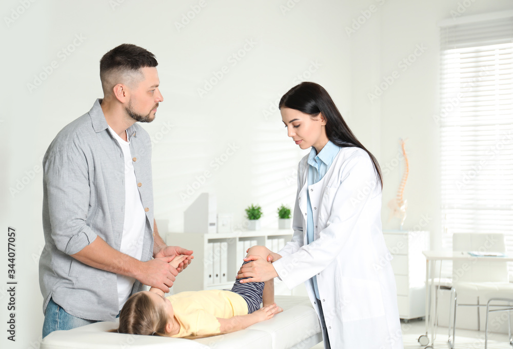 Obraz premium Professional orthopedist examining little patient's leg in clinic