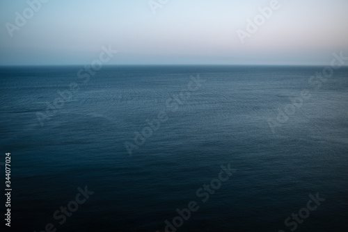 Maritime and minimalist view of the horizon with dark blue sea and cloudless sky.