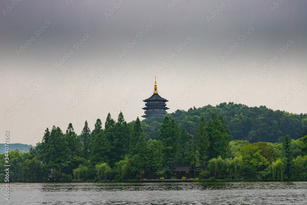 Pagoda surrounded by green trees in West Lake gardens in Hangzhou, China
