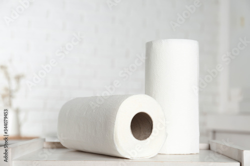 Rolls of paper towels on white wooden table in kitchen
