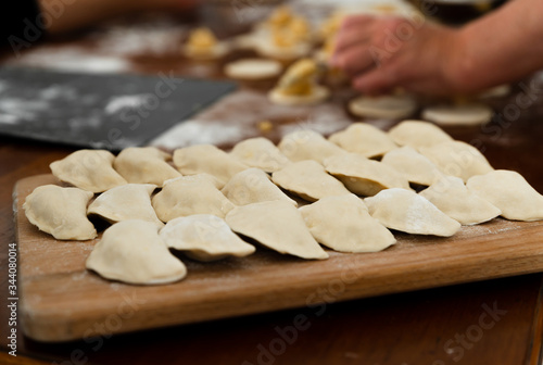 National dish,raw dumplings lie on a wooden board,homemade cooking dumplings with meat,beautifully arranged dumplings