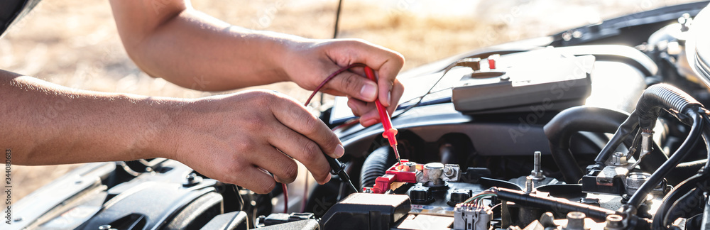 Mechanic repairman checking engine automotive in auto repair service and  using digital multimeter testing battery to measure various values and  analyze Stock Photo | Adobe Stock