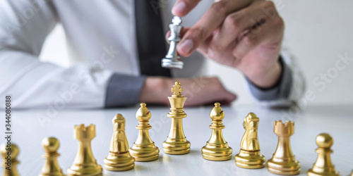 Gold and silver chess with player, Hands of businessman moving chess figure in competition to planning strategy to success play for win