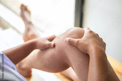 Doctor or Physiotherapist working examining treating injured leg of athlete male patient, Doing the Rehabilitation therapy pain in clinic