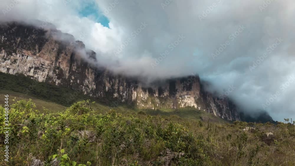Low angle view of the Roraima wall mountain range with an active cloud movement. Daytime, bright. Low angle view of the Roraima wall mountain range with an active cloud movement. Daytime, bright.