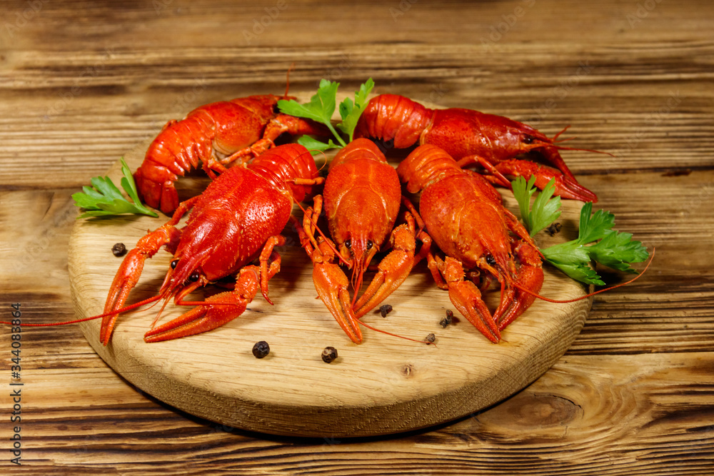 Boiled crayfish on cutting board on wooden table Boiled crayfish on cutting board on wooden table